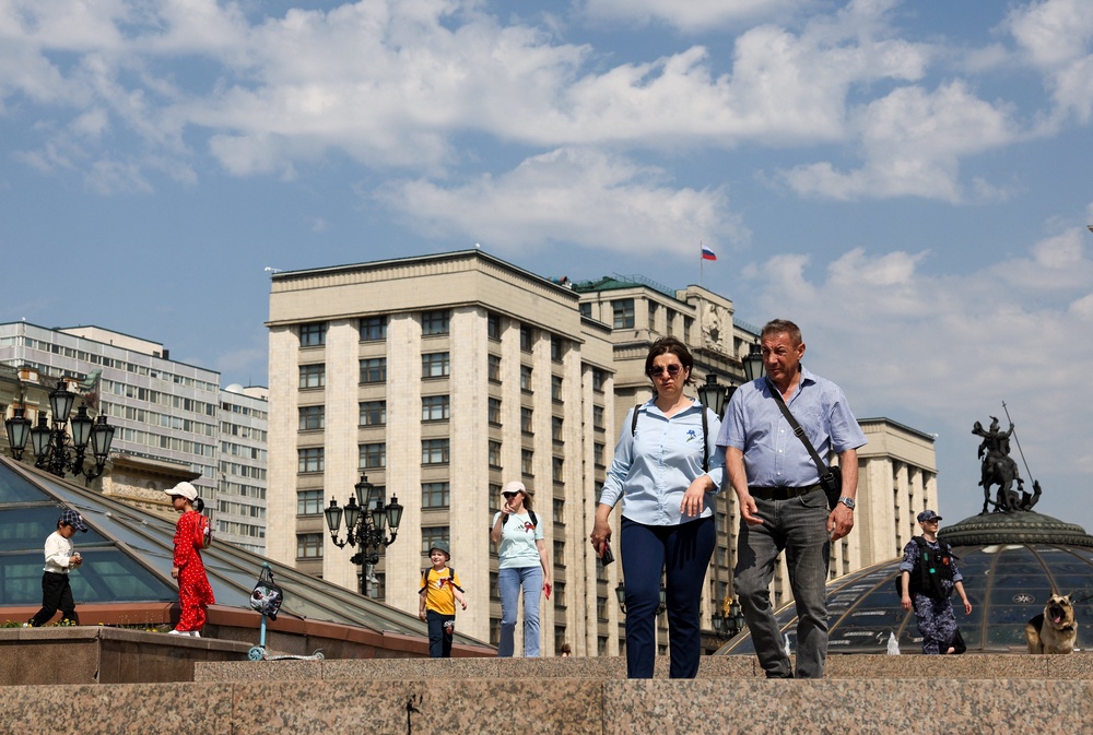 People walk in a square near the headquarters of the lower house of Russia’s parliament, the State Duma, in central Moscow (Reuters)