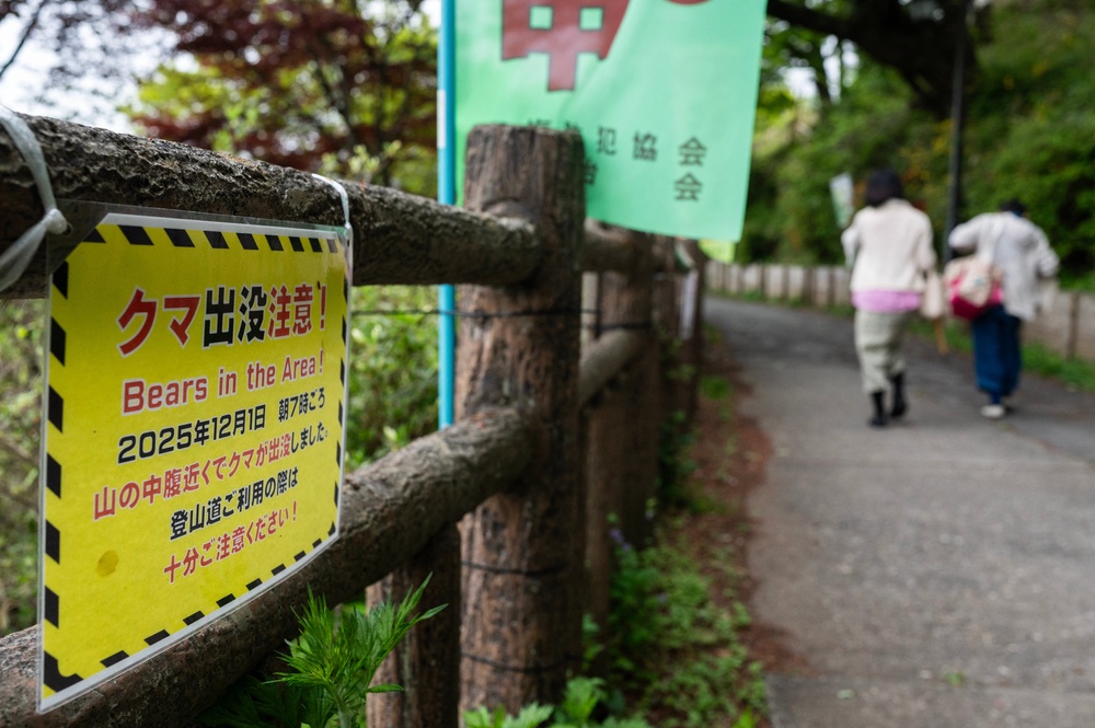 Hikers walk past a sign warning of bears in the area in Ome, Tokyo (AFP/Getty)