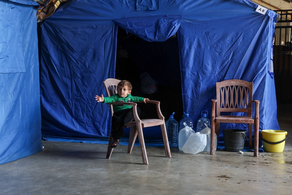 A child sits on a chair near a tent inside the Camille Chamoun Sports City Stadium, turned into a temporary shelter in Beirut, Lebanon, May 8 (Reuters)