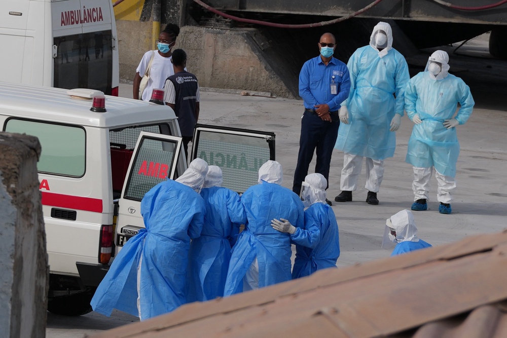 Health workers in protective gear evacuate patients from the MV Hondius cruise ship to an ambulance in Praia, Cape Verde on 6 May (AP)