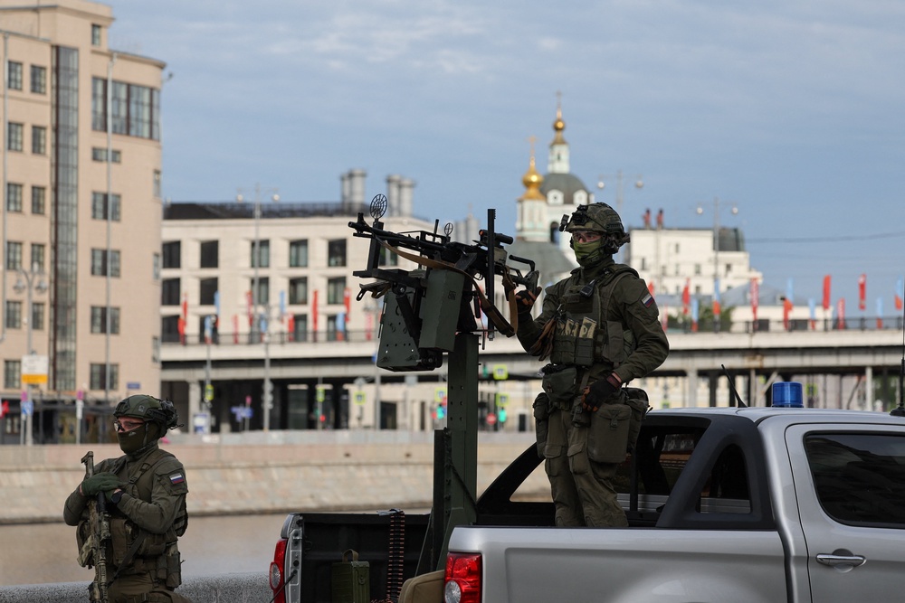 Russian security personnel patrol an area on a pickup truck armed with a machine gun amid increased security measures taken before a military parade on Victory Day (Reuters)
