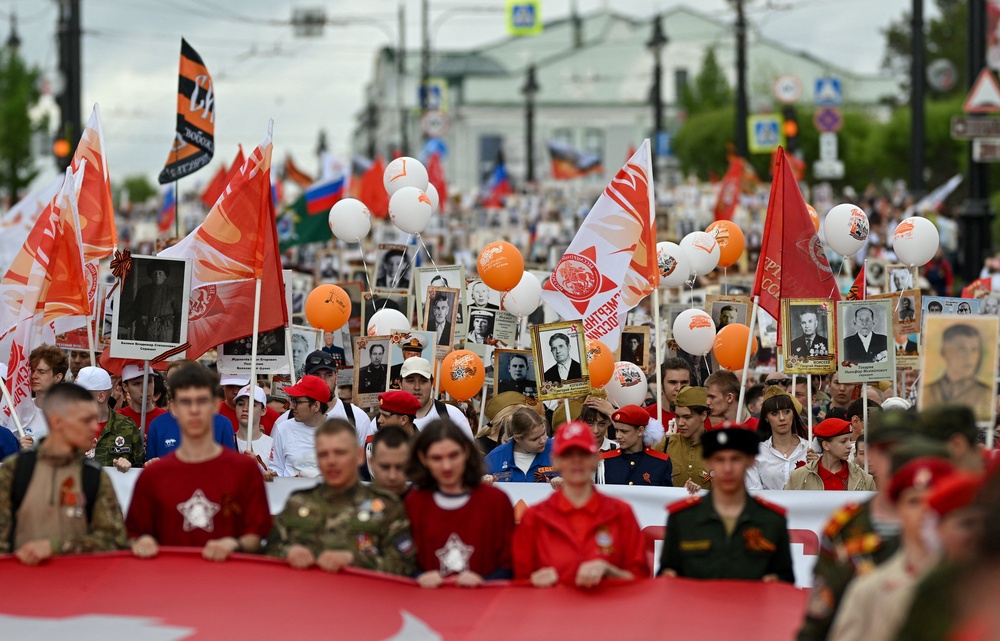 Participants carry portraits of people, including Red Army soldiers and veterans, during the Immortal Regiment march on Victory Day (Reuters)