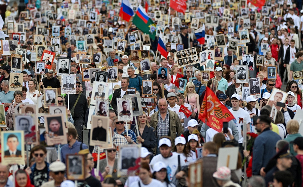 Participants carry portraits of people, including Red Army soldiers and veterans, during the Immortal Regiment march on Victory Day (Reuters)