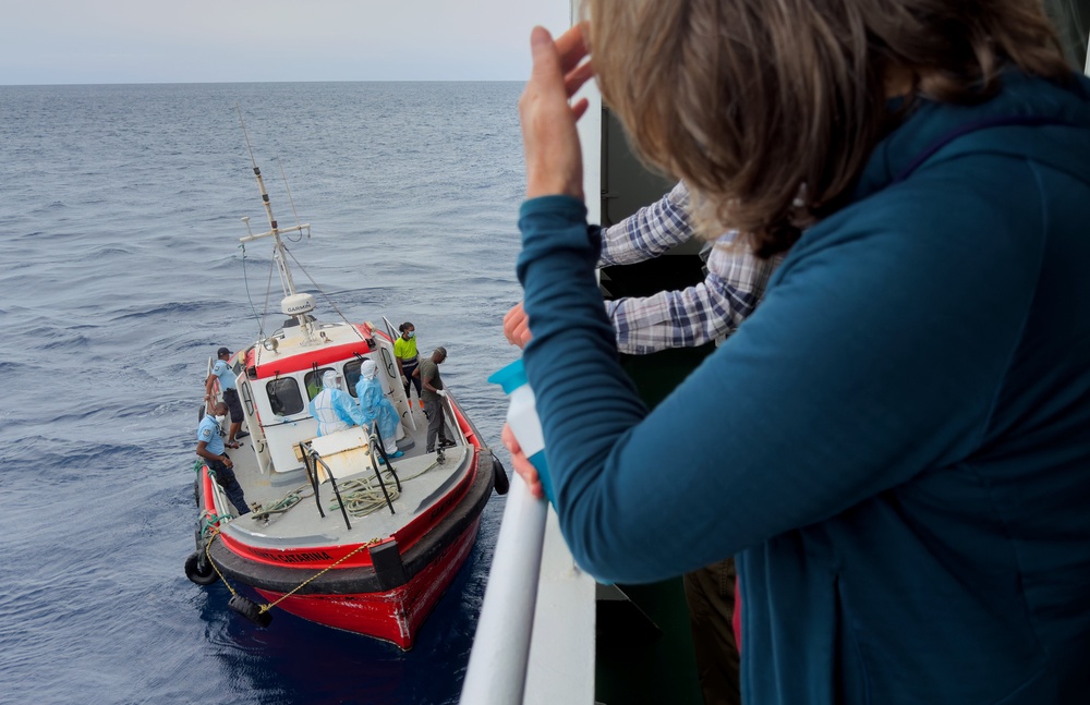 Passengers on the the hantavirus-stricken cruise ship, MV Hondius, watch epidemiologists board the boat in Praia, during their voyage to Tenerife (AP) (AP)