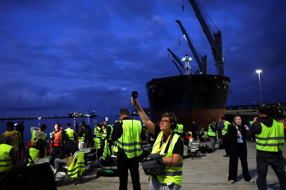 Members of the media work at the port of Granadilla de Abona following the arrival of the cruise ship (Reuters)