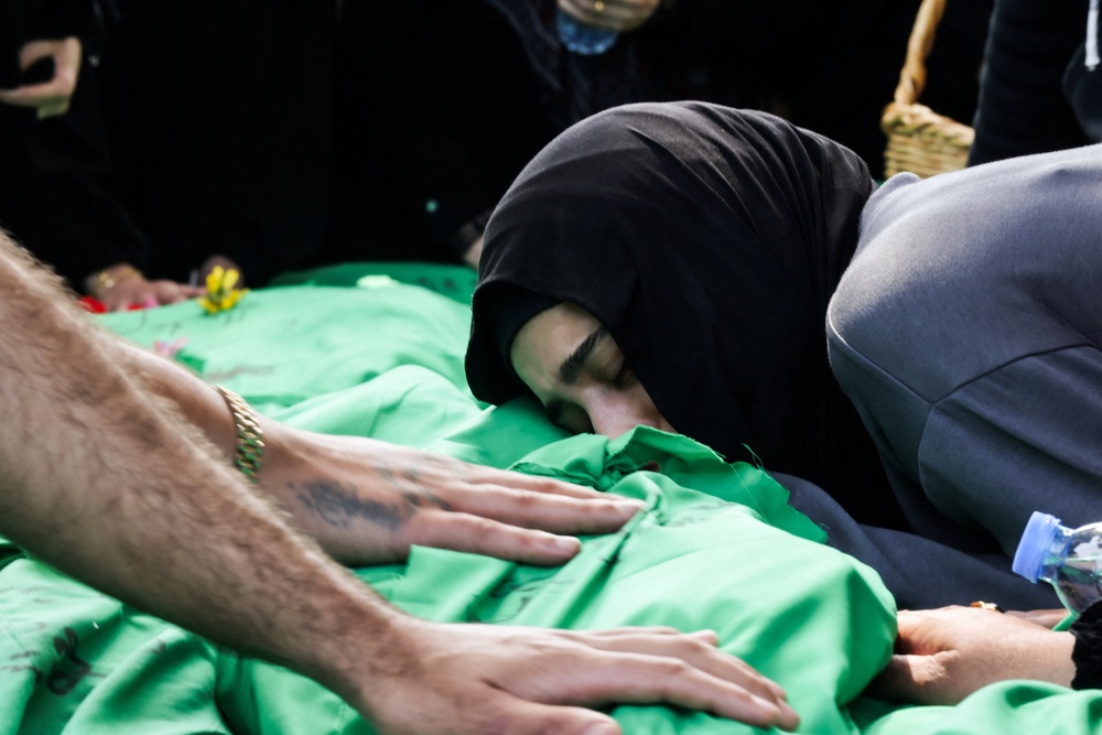 A women grieves as she rests her head on one of nine people killed the day before in an Israeli airstrike on the southern Lebanese village of Jibshit (AFP/Getty)