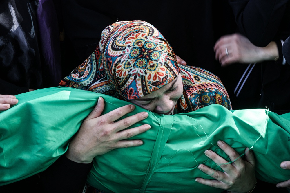 A Lebanese woman holds the body of a child, one of nine people killed the day before in an Israeli airstrike on the southern Lebanese village of Jibshit (AFP/Getty)