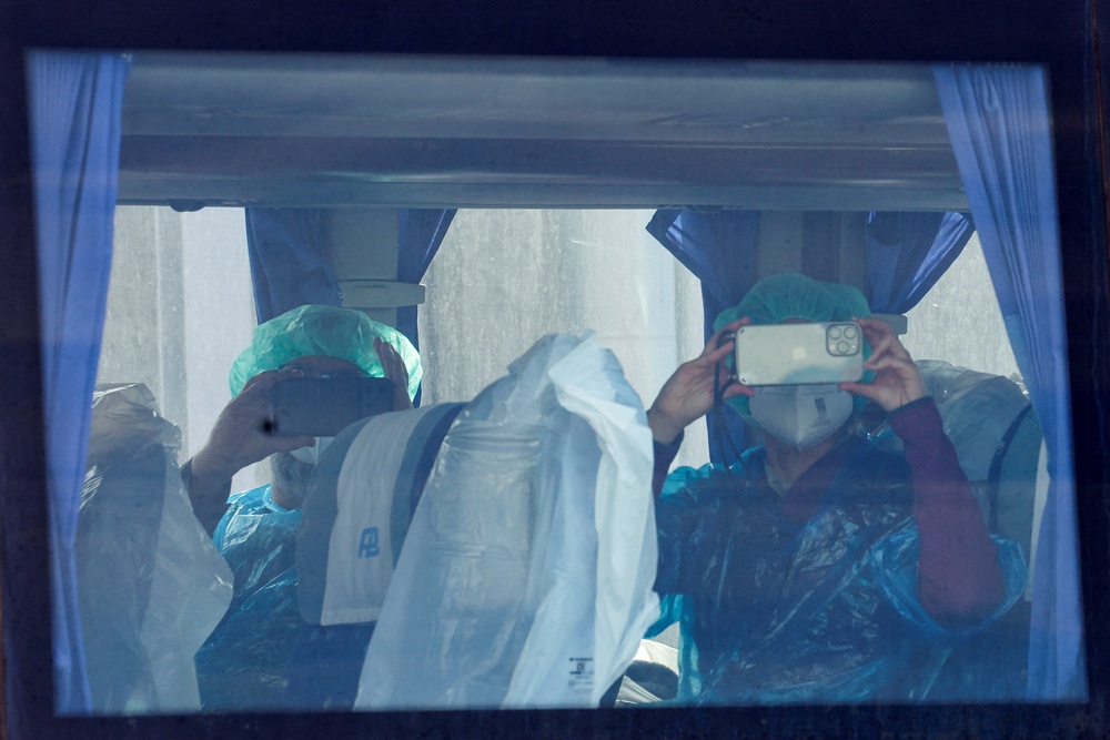 Passengers from the cruise ship MV Hondius, affected by a hantavirus outbreak, record using their mobile phones (Reuters)