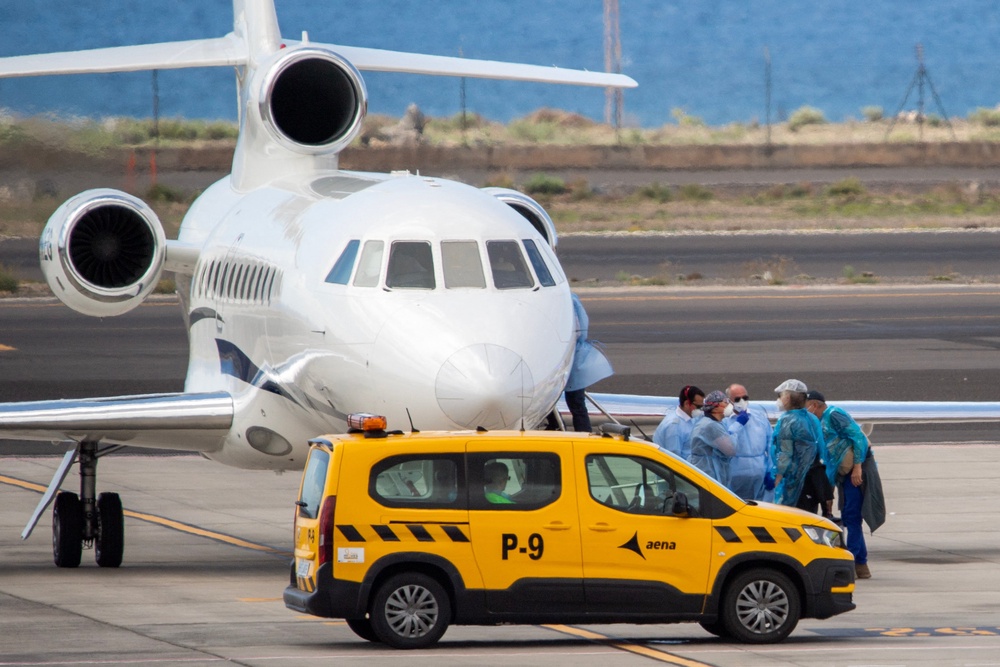 Passengers wearing blue protective suits board a French government plane after being evacuated from the hantavirus-stricken cruise ship (AFP/Getty)