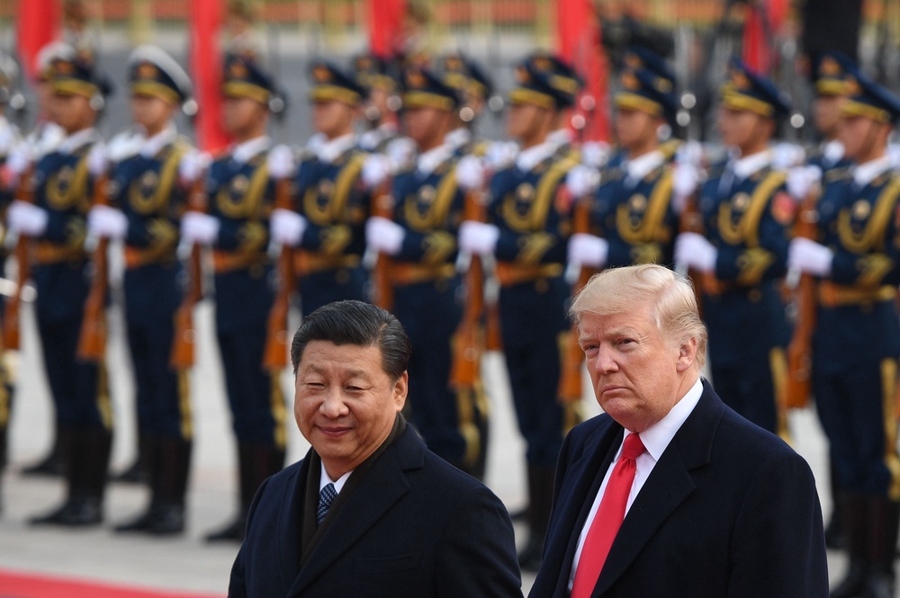 President Xi Jinping and Donald Trump review Chinese honour guards during a welcome ceremony at the Great Hall of the People in Beijing in November 2017 (AFP/Getty)