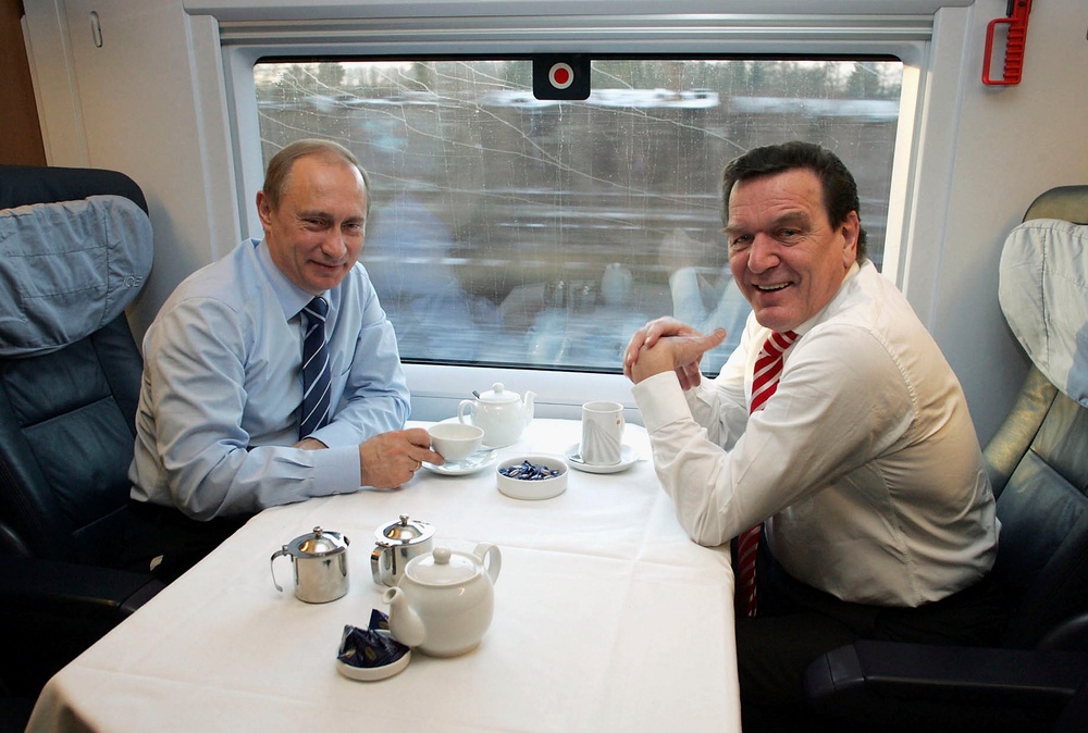 The Russian president and German chancellor Gerhard Schroeder travel on a high-speed train in 2004 (Getty)
