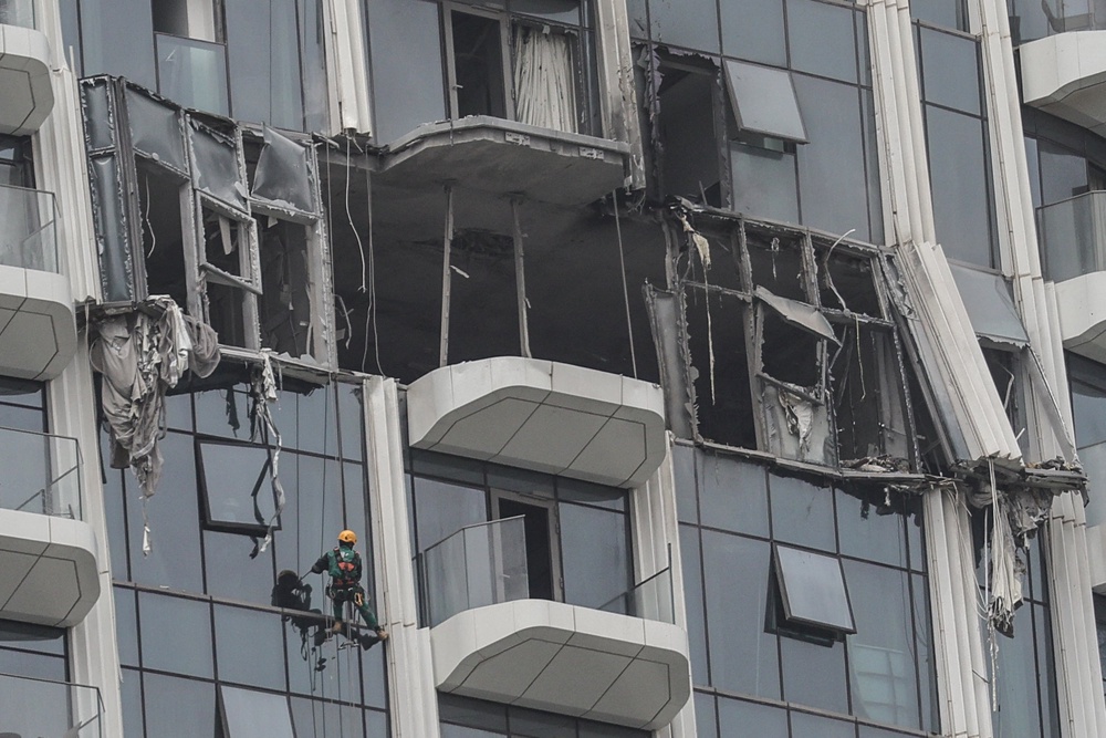 A steeplejack assesses the damage after a drone strike in Dubai's Creek Harbour (AFP/Getty)