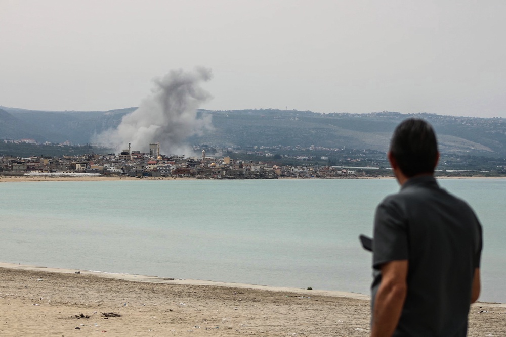 A man standing on the beach in the area of Tyre looks at smoke rising from the site of an Israeli airstrike in the area of Ras Al-Ain on May 12 (AFP/Getty)