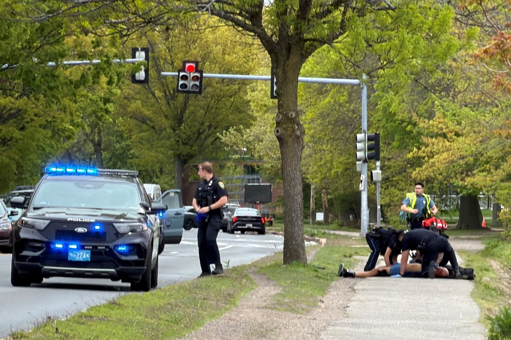 The suspect is treated by police officers on the sidewalk after being suppressed (Reuters)