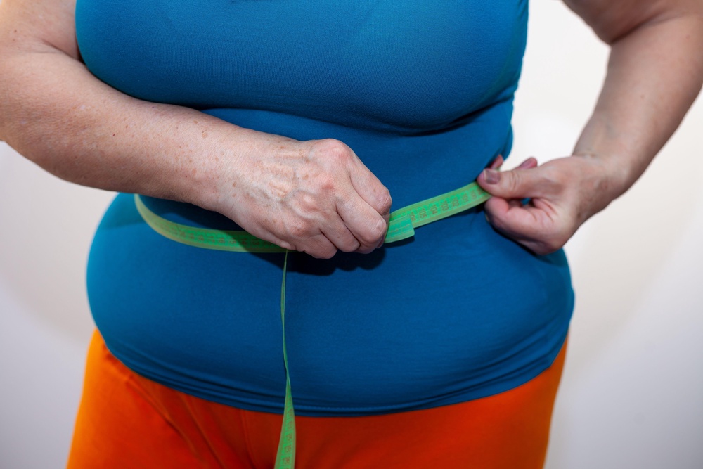 Close up picture of woman measuring waist with a tape measure (Alamy/PA)
