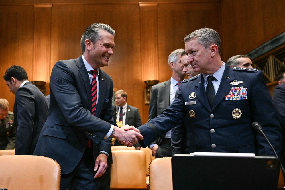 Hegseth and Caine shake hands as they prepare to testify before the Senate Appropriations Subcommittee on Defense (AFP/Getty)