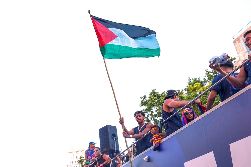 Lamine Yamal waved a Palestinian flag at the title parade (AP)