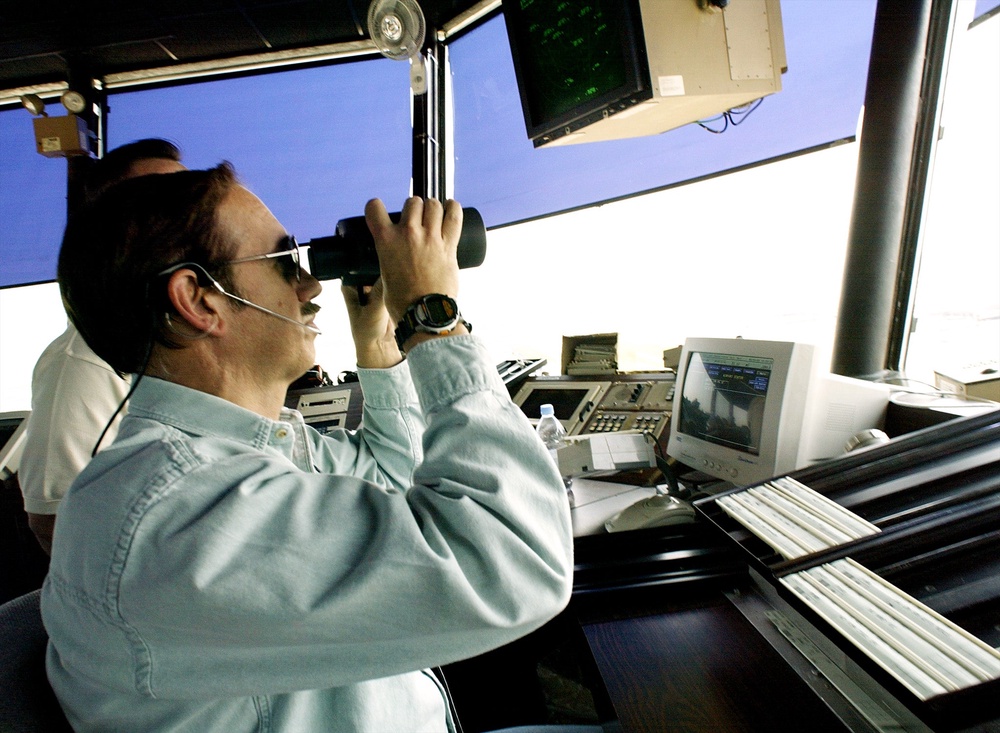 An air traffic controller uses binoculars to scan the sky at Dulles Airport in Virginia on Sept. 3, 2002. The Federal Aviation Administration is grappling with a shortage of controllers blamed on reduced hiring and attrition during the 2010s and the COVID-19 pandemic (AFP/Getty)