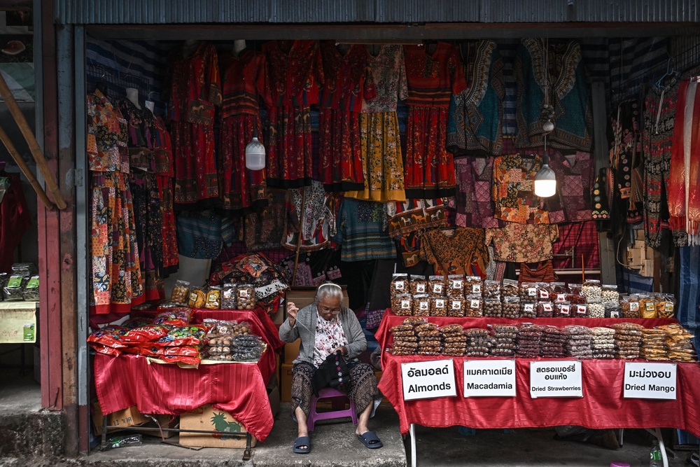 Hmong vendor sewing clothing at a stall selling souvenirs for tourists in the Hmong Doi Pui Village in the Doi Suthep-Pui National Park area of Chiang Mai (AFP/Getty)