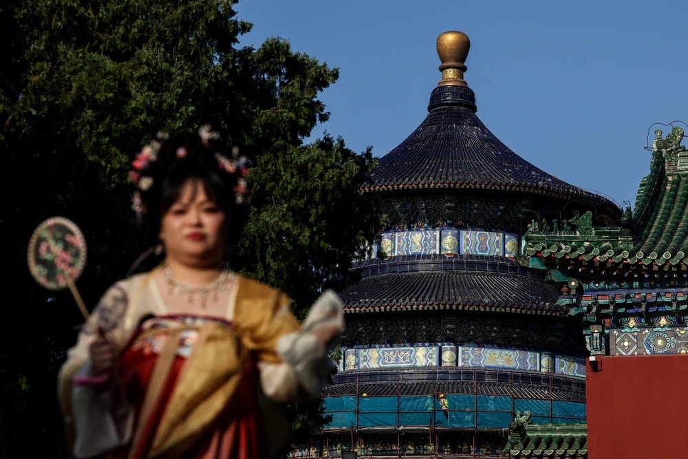 A woman dressed in traditional dress looks on next to the Hall of Prayer for Good Harvests at the Temple of Heaven, or Tiantan Park, ahead of this week’s U.S. President Donald Trump's visit to China (Reuters)