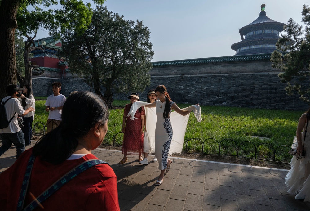 People pose for photos outside the closed Hall of Prayer for Good Harvests at the Temple of Heaven (Getty)