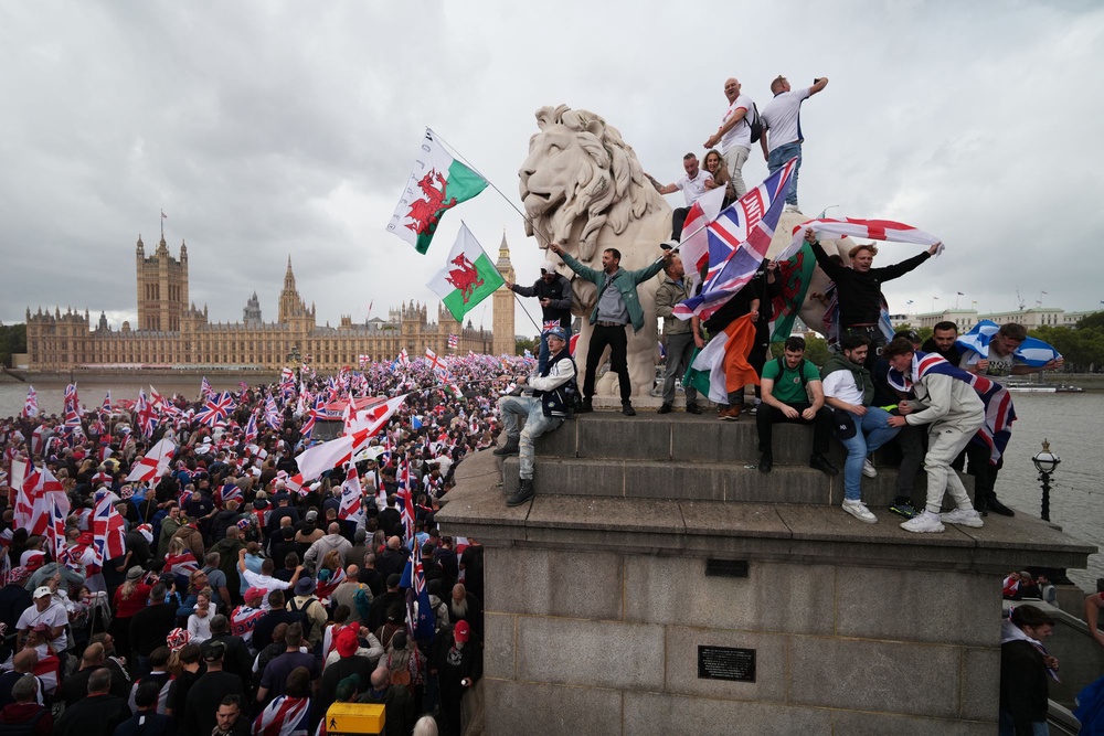 Protesters wave Union Jack and St George’s England flags during the Unite the Kingdom rally in September 2025 (Getty)