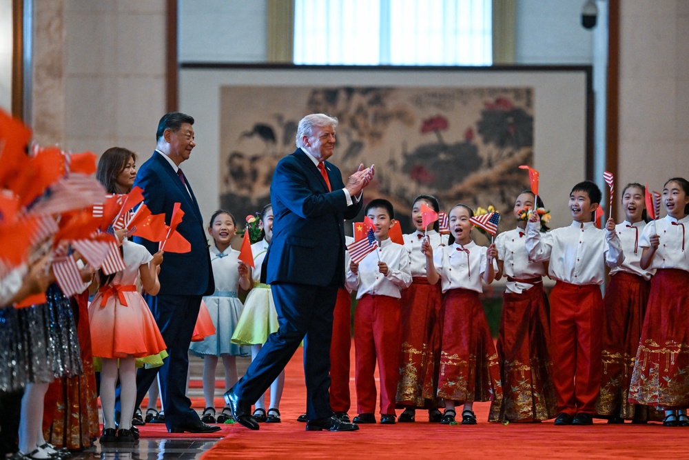 US President Donald Trump (R) and China's President Xi Jinping (L) greet children waving Chinese and US national flags and flowers during a welcome ceremony at the Great Hall of the People (AFP/Getty)