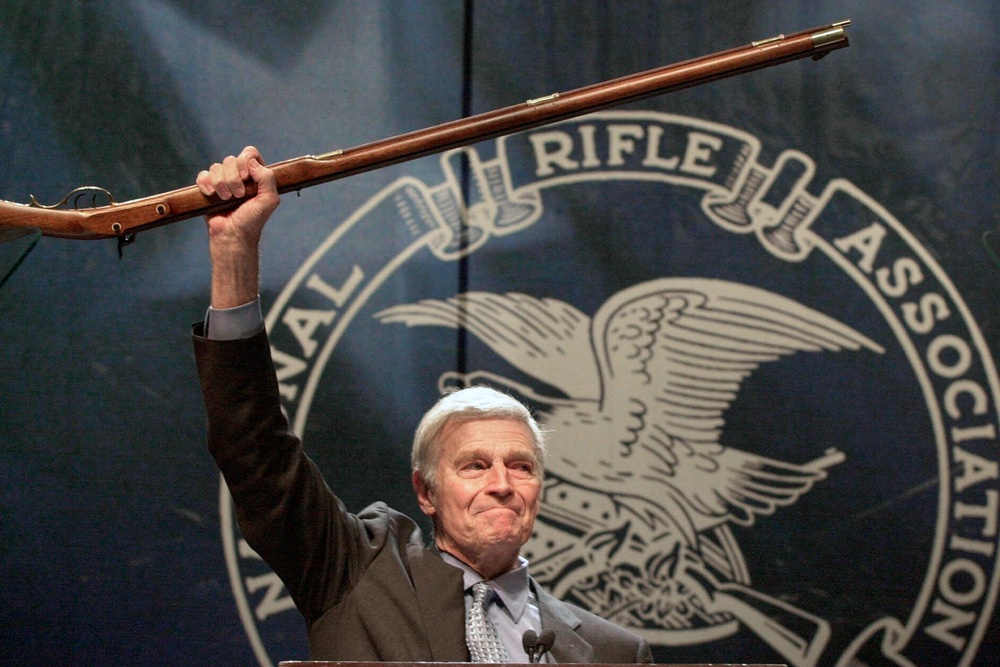NRA president Charlton Heston holds up a musket as he tells the members attending the 129th Annual Meeting & Exhibit in Charlotte, N.C., that they can have his gun when they pry it, 