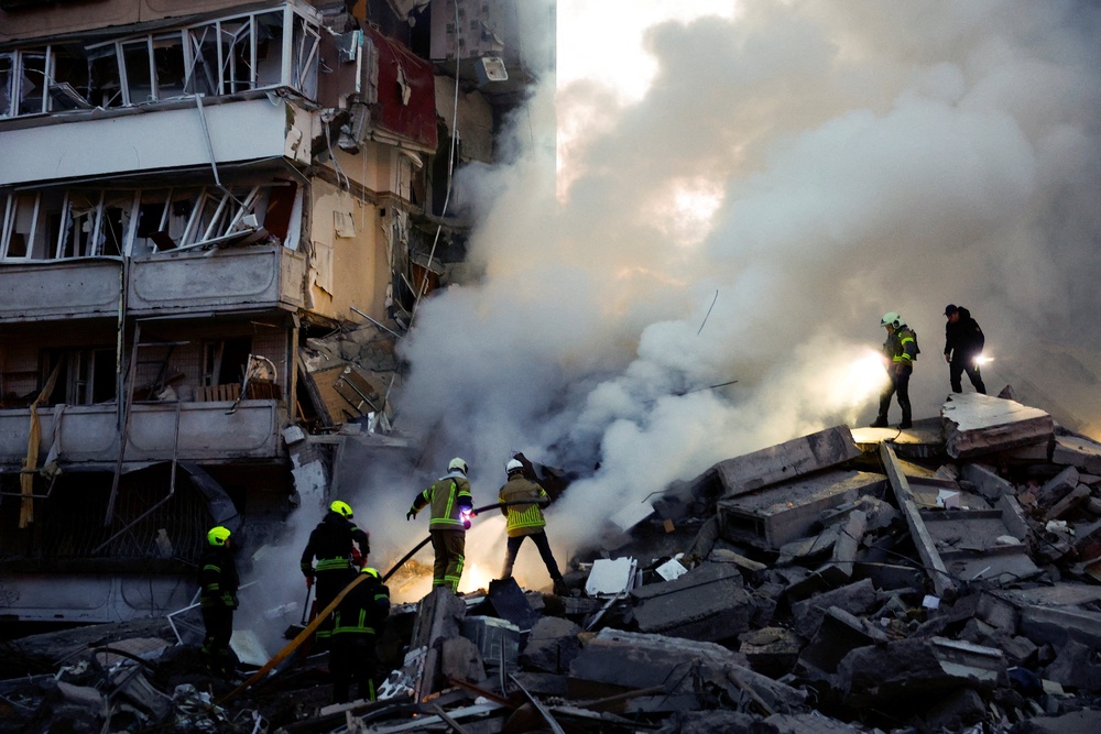 Rescuers search for people under the debris at the site of an apartment building damaged during Russian missile and drone strikes in Kyiv (Reuters)
