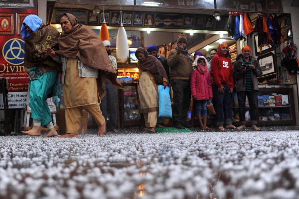 File. People take shelter outside a gift shop after a hailstorm in Amritsar (AFP via Getty)