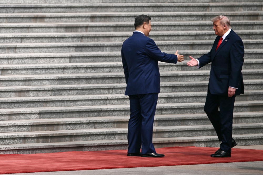 President Donald Trump initiates a handshake with Chinese leader Xi Jinping in front of the Great Hall of the People in Beijing Wednesday (AFP/Getty)