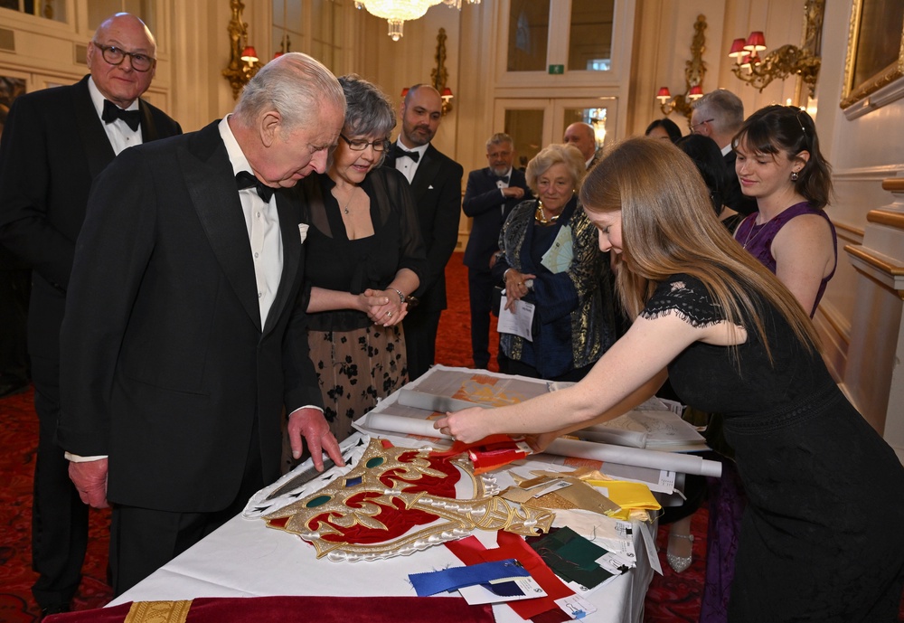 Charles speaks to Anne Butcher, from the Royal School of Needlework (right), as he views a display of items used to create the new curtains (Jeff Spicer/PA) (PA Wire)
