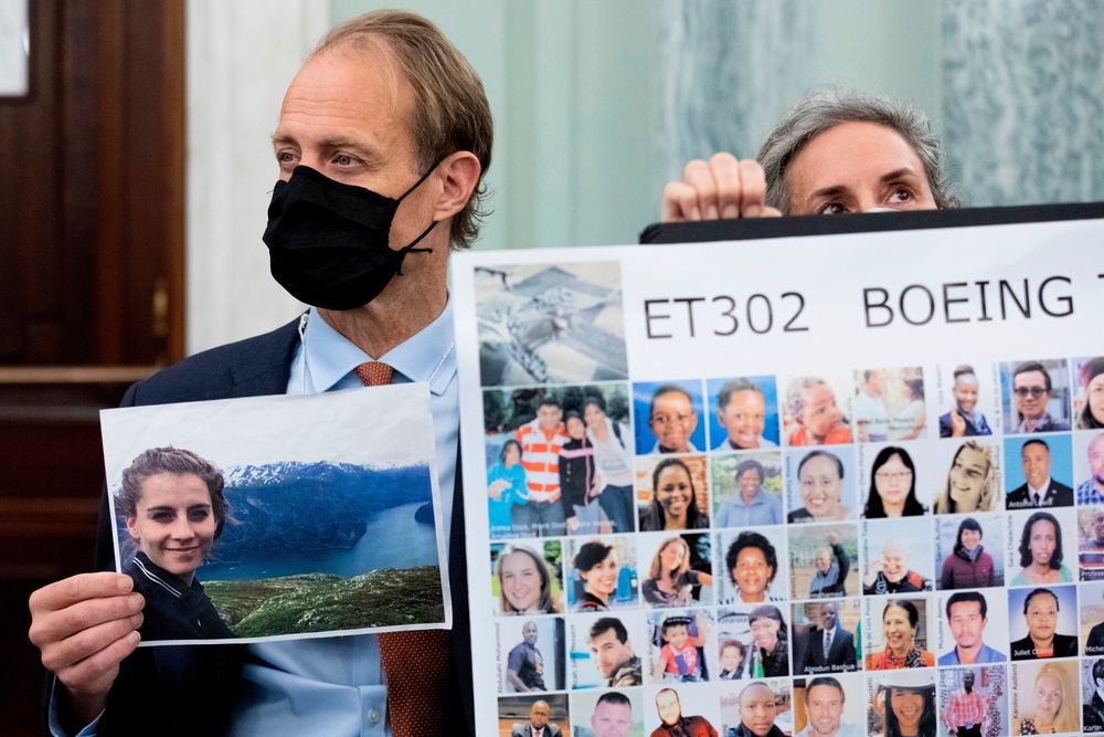 Michael Stumo, holding a photo of his daughter Samya Stumo, and his wife Nadia Milleron, sit behind FAA Administrator Steve Dickson during a Senate Committee (AP)