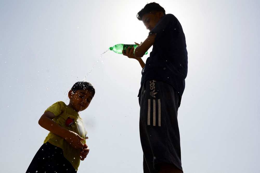 Children cool off with water during a scorching summer afternoon in Lahore, Pakistan, (AFP/Getty)