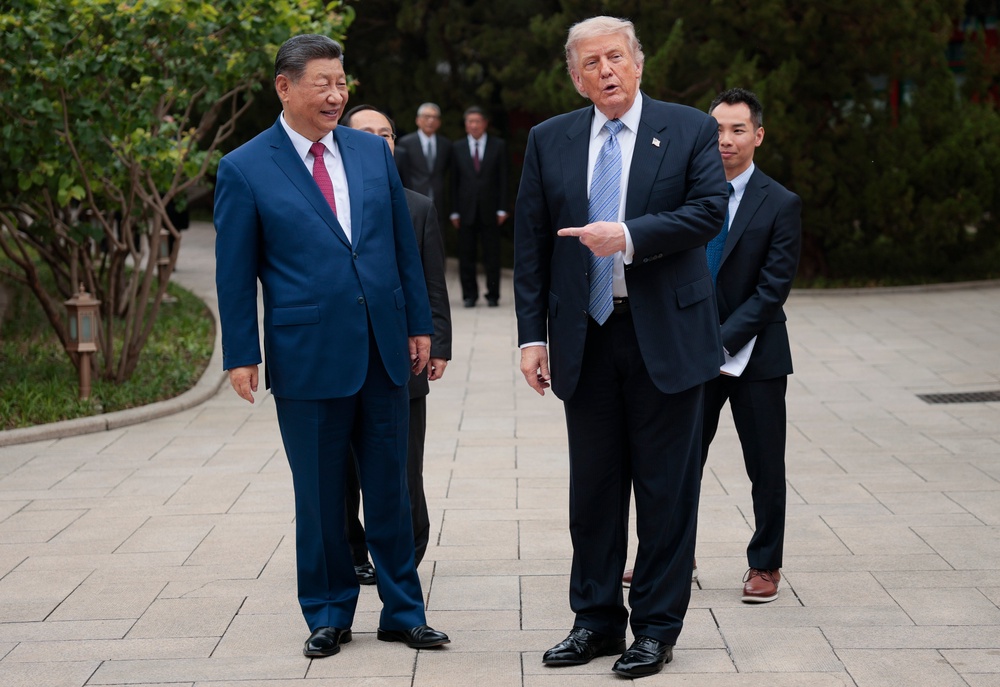 Trump gesturing towards Xi as he speaks to reporters (Getty)