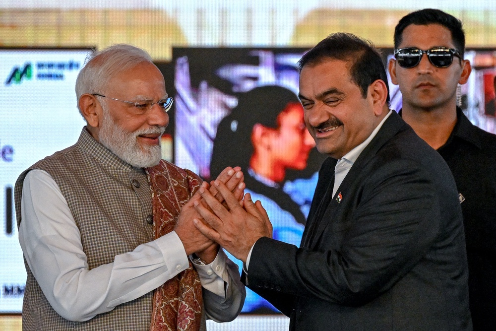India's prime minister Narendra Modi greets Gautam Adani, chairperson of Indian conglomerate Adani Group, during the inauguration ceremony of phase one of the Navi Mumbai International Airport in Navi Mumbai (AFP/Getty)