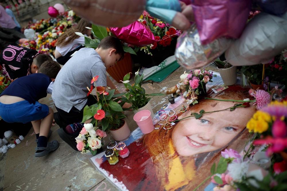 People leave flowers in honour of the Southport victims outside the Town Hall following the attack