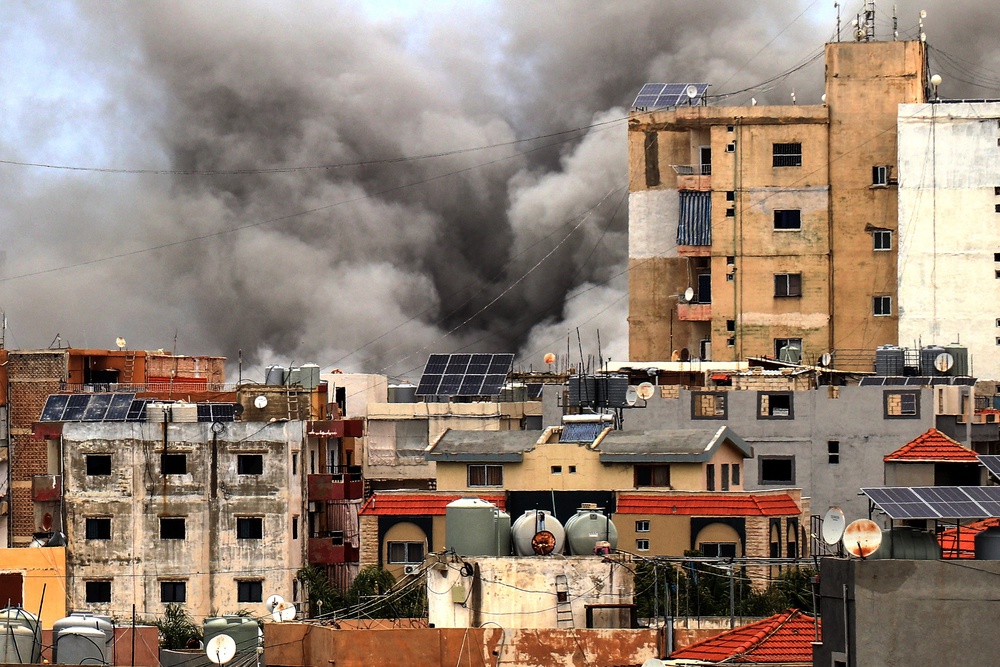Smoke rises behind buildings following an Israeli airstrike in the southern city of Tyre on May 15 (AFP/Getty)
