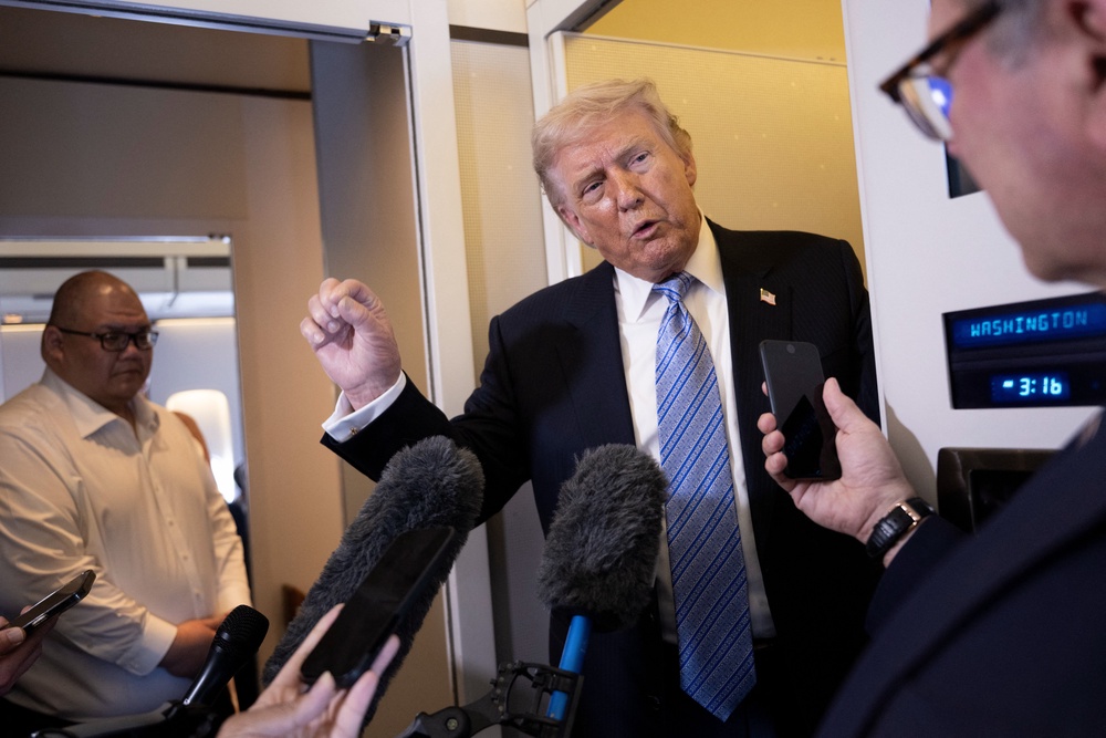 Donald Trump speaks to reporters aboard Air Force One after his departure from Beijing on May 15, heading back to the US (AFP/Getty)