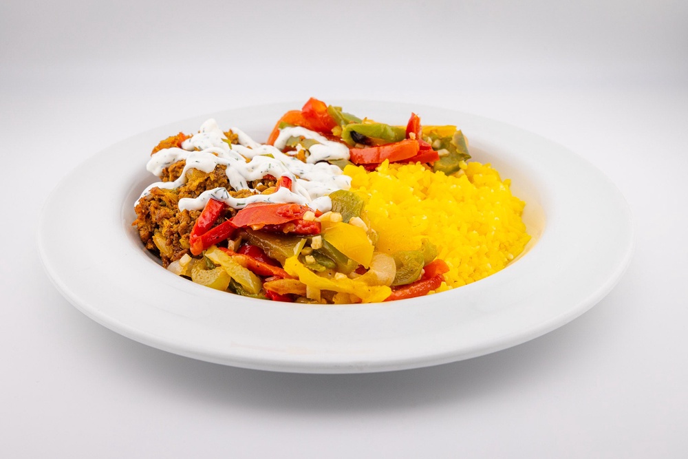 This hospital dish is entirely vegan — spice-rubbed shawarma mushrooms over golden rice with plant-based tzatziki and savory sautéed peppers (NYC Health and Hospitals)