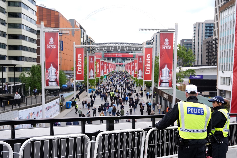 Police officers looks over fans on Wembley Way ahead of the Emirates FA Cup final at Wembley Stadium (Jonathan Brady/PA Wire)