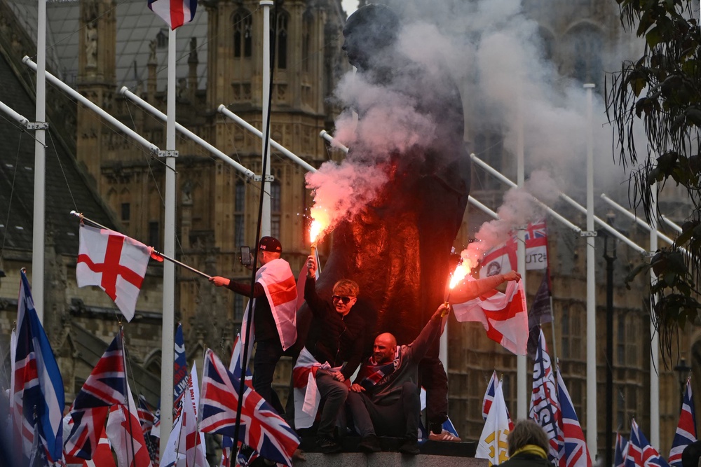 In Parliament Square, supporters of British far-right activist Tommy Robinson, real name Stephen Yaxley-Lennon, let off flares beside the statue of Winston Churchill (AFP/Getty)