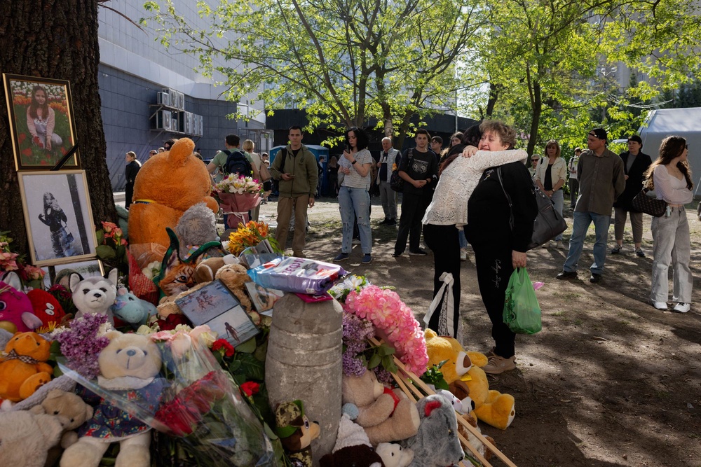 Local residents gather at a makeshift memorial near a partially destroyed residential building in Kyiv on May 15, 2026 (AFP via Getty Images)