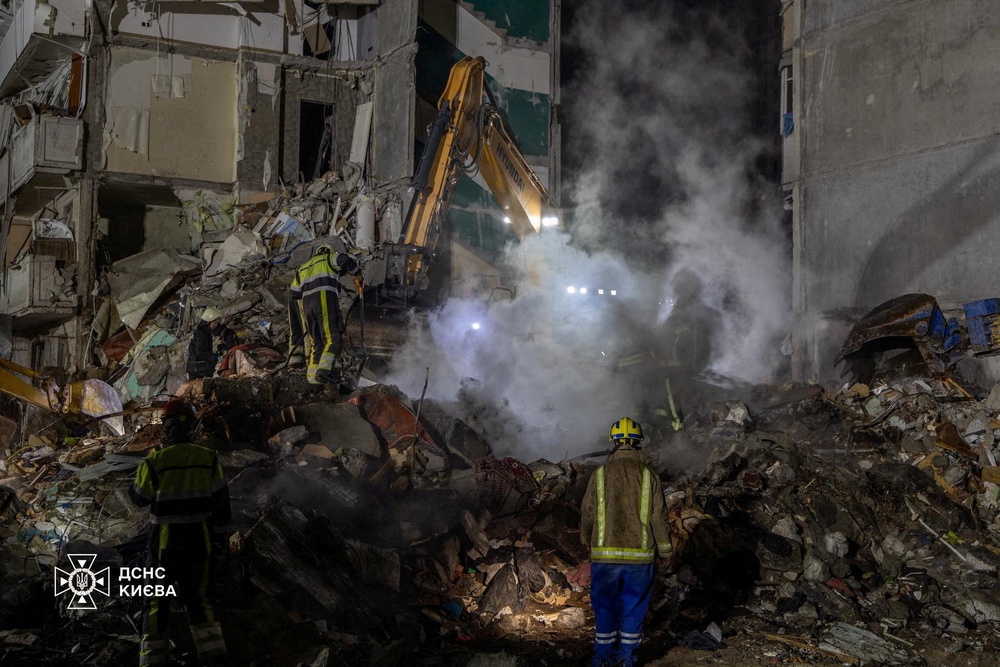 Emergency services working at the site of a damaged apartment building (via REUTERS)