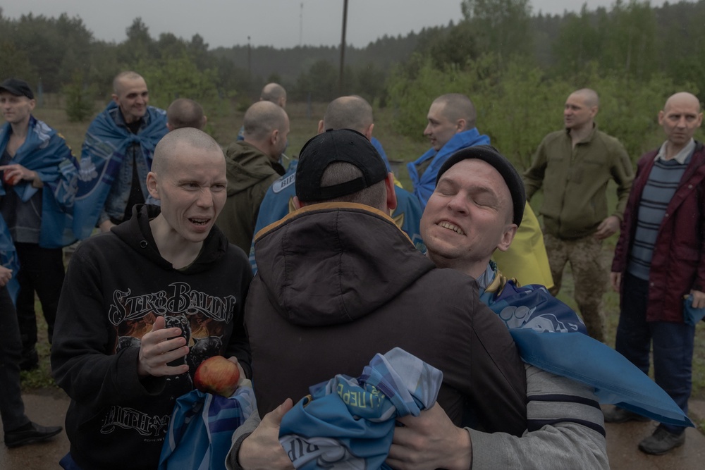 Released Ukrainian prisoners of war (POWs) embrace each other following a prisoner exchange (AFP via Getty Images)