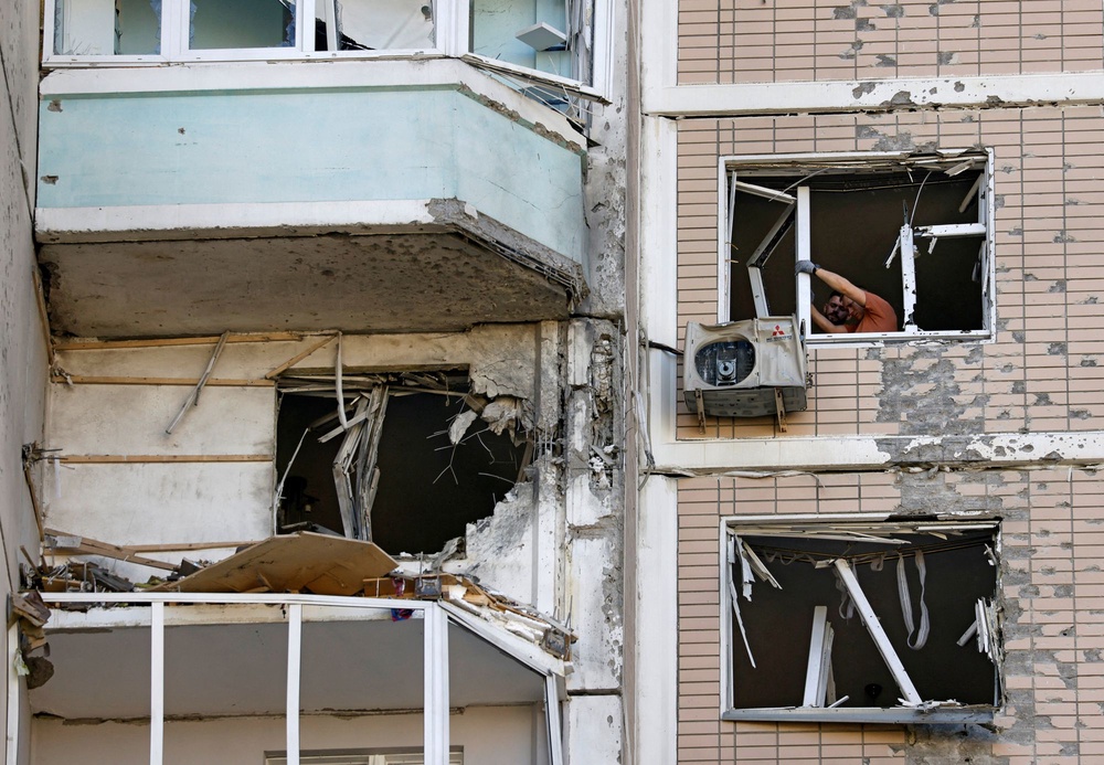 Residents clear broken windows in a damaged apartment building following a Ukrainian drone attack in the course of Russia-Ukraine (REUTERS)