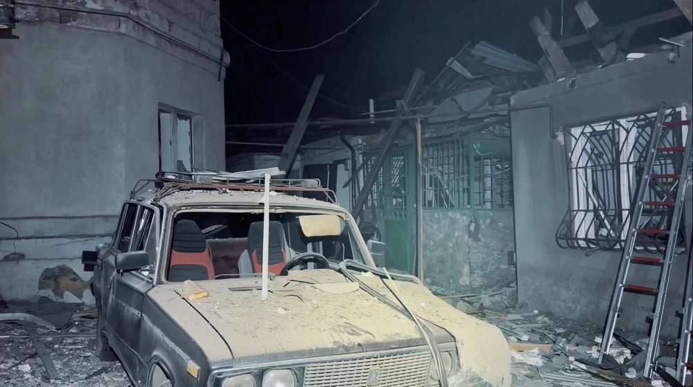 A destroyed car and damaged buildings at the site of a Russian drone strike in Odesa (Reuters)