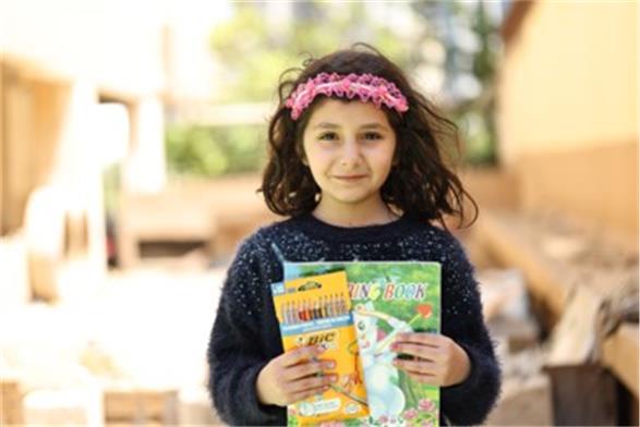 Naya, six, enjoys using her colouring book, but wants to start learning again (Save the Children)
