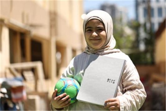 Tala, 10, brought her notebook so she could continue her studies in a displacement camp (Save the Children)