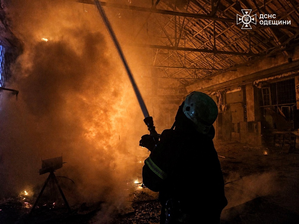 A firefighter tries to douse fire at compound of a port which was hit during overnight Russian drone strikes in the town of Izmail in Odesa (Reuters)